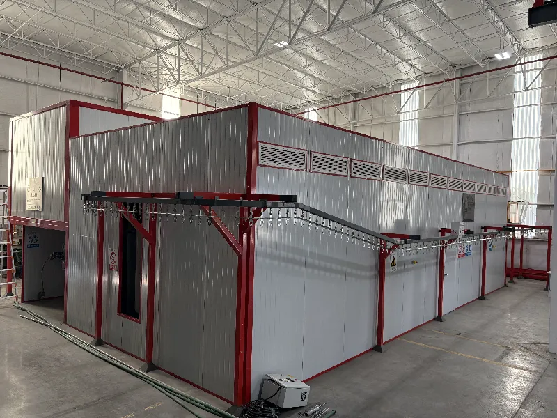 Cabina automática de pintura en polvo con transportador aéreo en el taller de acabado de México