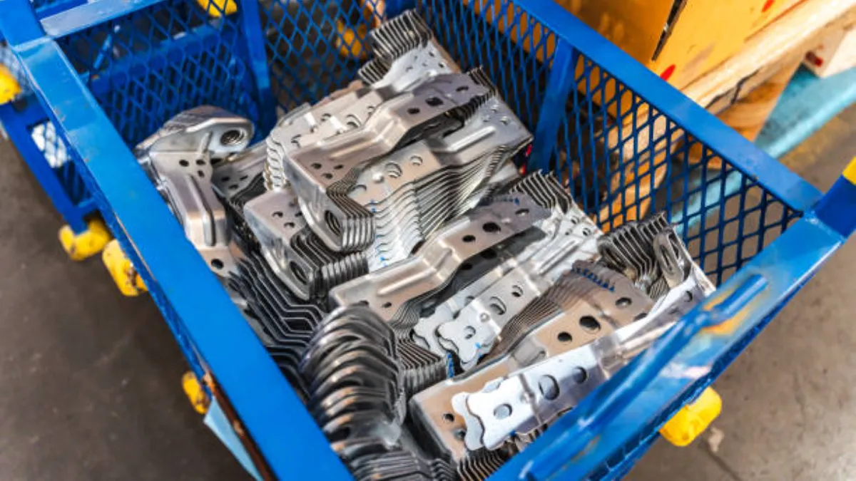 Bin of small machined die-cast brackets, the latch and lever class where the copper-strengthened alloy is common
